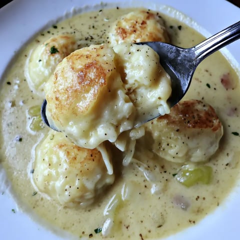 Plato de sopa con bolas de queso y verduras.